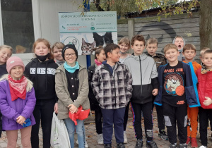 Uczniowie klasy III D stoją grupą przed Schroniskiem dla Bezdomnych Zwierząt w Koninie.